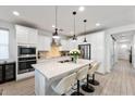 Modern kitchen with stainless steel appliances, a large island with seating, and stylish pendant lighting at 3890 E Dublin St, Gilbert, AZ 85295