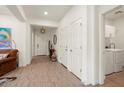 Bright hallway featuring tile floors, white trim and walls, and a laundry room entrance at 4728 N 204Th Ln, Buckeye, AZ 85396