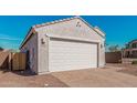 A two-car garage with a brick paver driveway, and low-maintenance desert landscaping at 6722 W Desert Dr, Laveen, AZ 85339