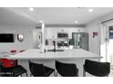 Well-lit kitchen boasts stainless steel appliances, white cabinets, an island with seating, and modern finishes at 7407 E Polk St, Scottsdale, AZ 85257