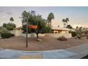 Desert home exterior with a circular driveway, mature trees, and distinctive architecture at 9457 N 80Th Pl, Scottsdale, AZ 85258