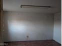 A vacant bedroom with white walls and minimal lighting at 9716 E Birchwood Ave, Mesa, AZ 85208