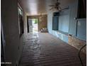 A living room features unfinished walls, wooden floors and a ceiling fan at 9716 E Birchwood Ave, Mesa, AZ 85208