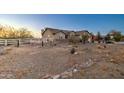 Desert home featuring gravel yard with white wood fence in background at 12326 N Lang Rd, Florence, AZ 85132