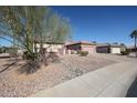 A single story home featuring gravel landscaping, desert foliage, and a tile roof on a clear day at 15712 W Eucalyptus Ct, Surprise, AZ 85374