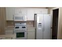 Functional white kitchen featuring gas range, microwave, matching white refrigerator and ample cabinetry at 15971 N 91St Dr, Peoria, AZ 85382