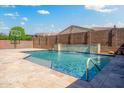 Sparkling pool features a baja shelf, stone waterfall feature, and a basketball court at 16074 W Cortez St, Surprise, AZ 85379