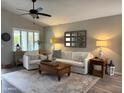 Cozy living room with plush seating, a ceiling fan, and a decorative mirror over a sofa at 20315 N 82Nd Ln, Peoria, AZ 85382