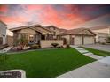 Beautiful home exterior with a well-manicured lawn, stone accents, and a three-car garage at sunset at 21666 N 53Rd Dr, Glendale, AZ 85308