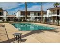 Community pool surrounded by condos with shaded seating areas and lush landscaping at 240 S Old Litchfield Rd # 206, Litchfield Park, AZ 85340