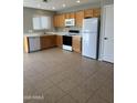 Bright kitchen with white appliances, wood cabinets, and tile flooring at 2837 W Angela Dr, Phoenix, AZ 85053