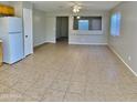 Bright living room featuring neutral walls, tile flooring, ceiling fan, and open layout to the rest of the home at 2837 W Angela Dr, Phoenix, AZ 85053