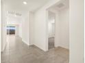 Bright hallway with tile flooring, leading to an open living space and a view of the outdoor patio at 37093 W La Paz St, Maricopa, AZ 85138