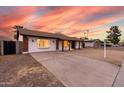 Single-story home boasting a well-lit entrance and a wide driveway, enhanced by desert landscaping at 4052 W Eva St, Phoenix, AZ 85051