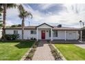 Charming home with red front door, manicured lawn, and lush landscaping at 4307 E Turney Ave, Phoenix, AZ 85018