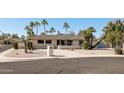 A charming single-story home with desert landscaping, palm trees, and a cozy front entrance at 4702 E Monte Cristo Ave, Phoenix, AZ 85032