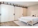 Bedroom with sliding barn doors, neutral colors, and an elegant white bed frame at 5100 N Miller Rd # 24, Scottsdale, AZ 85250