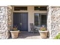 Elegant stone entrance, featuring double doors, potted plants and comfortable seating at 56 S Prairie Rd, Gilbert, AZ 85296