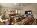 Comfortable living room features hardwood floors, a ceiling fan, and a large television at 650 N Hawes Rd # 4508, Mesa, AZ 85207