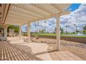 Covered patio overlooking lush green lawn with beautiful view of golf course, lake, and trees at 8147 E Lakeview Ave, Mesa, AZ 85209