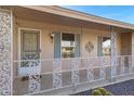 Close-up of front porch with decorative railing, blue shutters, and a security door at 9817 W Loma Blanca Dr, Sun City, AZ 85351