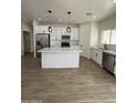 A modern kitchen featuring white cabinets, stainless steel appliances, and a large center island at 10281 W Concordia Dr, Arizona City, AZ 85123