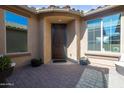 Inviting entryway with a wooden front door, covered porch, and planters, creating a warm and welcoming entrance to the home at 10778 W Whitehorn Way, Peoria, AZ 85383