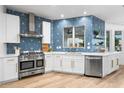 Kitchen featuring stainless steel appliances, white cabinetry, a gas range, and a modern geometric backsplash at 1157 N Date Palm Dr, Gilbert, AZ 85234