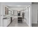 Bright kitchen featuring white cabinets, stainless steel appliances, dark countertops, and a large island with seating at 1610 W Wilshire Dr, Phoenix, AZ 85007