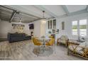 Cozy living room with dining area with ample lighting, fireplace, comfortable seating, and wood floors at 1610 W Wilshire Dr, Phoenix, AZ 85007