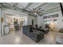 Open-concept living room boasts a modern ceiling fan, comfortable gray sectional sofa, and seamless flow into the kitchen at 1610 W Wilshire Dr, Phoenix, AZ 85007