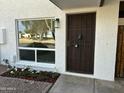 Inviting entryway featuring a secure metal door, white trimmed window, and well maintained flower bed at 1725 N Date -- # 23, Mesa, AZ 85201