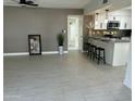 Open-concept living space with modern gray tile flooring leading to a kitchen with a breakfast bar at 1725 N Date -- # 23, Mesa, AZ 85201