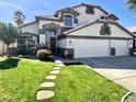 Charming two-story home featuring a well-manicured lawn, stepping stones, and a three car garage at 1865 E Pinto Dr, Gilbert, AZ 85296