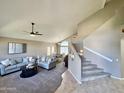 Bright living room showcases a neutral palette with comfortable seating, carpet floors, and open staircase at 1865 E Pinto Dr, Gilbert, AZ 85296