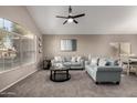 Cozy living room featuring plush seating and a modern ceiling fan at 1865 E Pinto Dr, Gilbert, AZ 85296