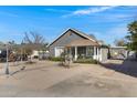 Quaint grey home with a tidy yard, a welcoming front porch, and a neatly paved driveway at 215 N Hobson --, Mesa, AZ 85203