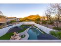 Inviting backyard oasis with a sparkling pool, lush artificial turf, and relaxing lounge area at 2226 E Parkside Ln, Phoenix, AZ 85024