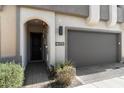 Close-up of a townhome's entrance with an attached garage and desert landscaping at 23065 N 75Th St, Scottsdale, AZ 85255