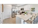 Kitchen with stainless steel appliances, white cabinetry, quartz countertops, and barstool seating at 25083 N 174Th Ln, Surprise, AZ 85387