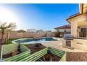 An outdoor kitchen with a grill sits near the pool in this spacious backyard at 26312 N 132Nd Ln, Peoria, AZ 85383