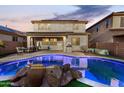 Inviting backyard features a sparkling pool with rock accents, covered patio, and outdoor seating at 26312 N 132Nd Ln, Peoria, AZ 85383