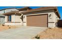 Wide driveway leading to a two-car garage, complemented by desert landscaping at 31541 N Wet Creek Rd, San Tan Valley, AZ 85143