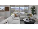 Bright living room featuring a modern sofa, mountain views, stylish pillows and a decorative coffee table at 3539 E Starflower Dr, Queen Creek, AZ 85142