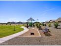 Playground and common area with walking paths, benches, and corn hole game surrounded by neighborhood homes at 4354 W Jeanette Ln, San Tan Valley, AZ 85144