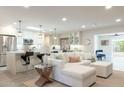 Open-concept living room with modern kitchen, sleek lighting, stainless appliances, and a comfortable white sofa at 5110 N 78Th St, Scottsdale, AZ 85250