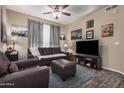Comfortable living room featuring leather seating, ceiling fan, and a mounted television at 5303 N 7Th St # 114, Phoenix, AZ 85014