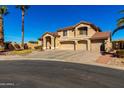 This is a view of the front exterior of a tan two-story home with a 4-car garage and desert landscaping at 5331 N Pajaro Ct, Litchfield Park, AZ 85340