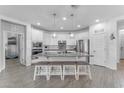 Bright kitchen featuring a large center island with barstool seating, stainless appliances, and pantry at 5637 S 29Th Pl, Phoenix, AZ 85040