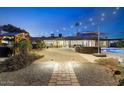 Backyard with a stone patio, built in seating, pool and desert landscaping at 6323 E Gold Dust Ave, Paradise Valley, AZ 85253